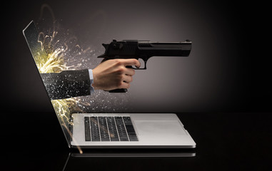 Hand with gun coming out of a laptop with sparkling effects