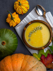 Vegetarian autumn pumpkin cream soup with seeds, color foliage