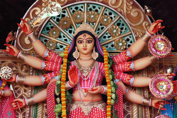 Goddess Durga idol at decorated Durga Puja pandal, shot at colored light, at Kolkata, West Bengal, India. Durga Puja is biggest religious festival of Hinduism and is now celebrated worldwide.