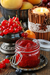 Jar of strawberry jam among summer and autumn fruits
