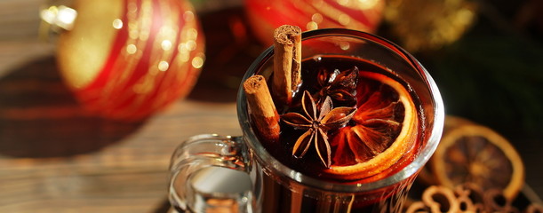 Christmas mulled vine with spices sinnamon stiks, anice stars, orange and New Year decorations on a wooden rustik table. Banner. Selective focus. Traditional hot drink at Xmas holiday © irenastar