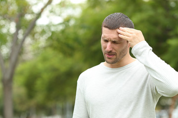 Man suffering head ache complaining in a park