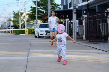 Little Child Girl Walking and Happy with Mother at The Garden Home