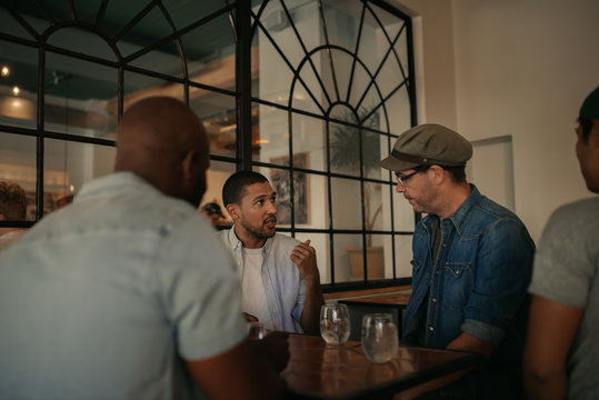 Group Of Guys Hanging Out Over Drinks In A Bar