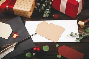 Empty letter with a feather on old  wooden background decorated with christmas objects