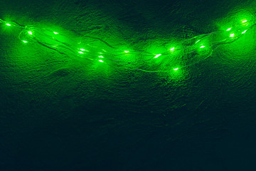 Garland with green light elements in the dark close up