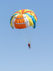 A parachute flies against a blue sky