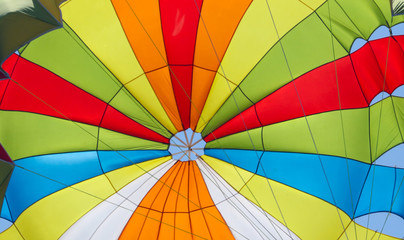 A multi-colored dome of a parachute in the sky as a background
