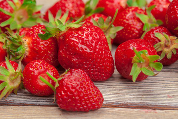 Red ripe strawberries on wooden table close up