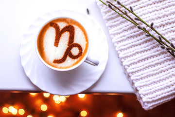 A cup of cappuccino coffee with a zodiac sign