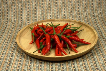 Fresh organic red chilly on the wood plate. Main ingredient in Thailand.