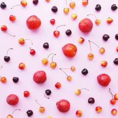 creative flat layout of fruits top view, plum and cherry on a pink background