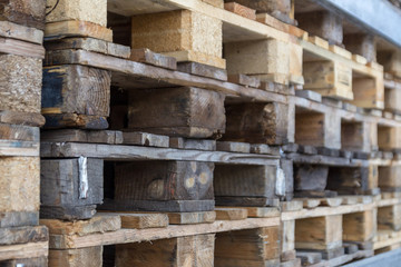 Close up of wooden cargo pallets overlap in warehouse. Selectiive focus.