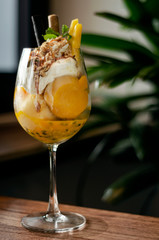mango and passion fruit tropical ice cream sundae in glass