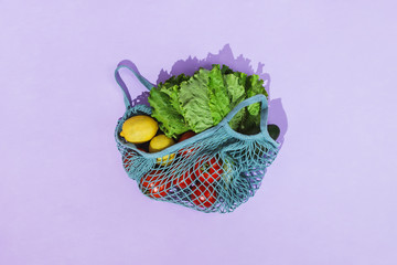 Zero-waste grocery shopping concept: various fruit and veggies in a mesh produce bag
