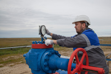 Gas operator, The operator operates the gas well with a torch.The mechanic - the repairman , Oil, gas industry. gas conditioning equipment and valve armature
