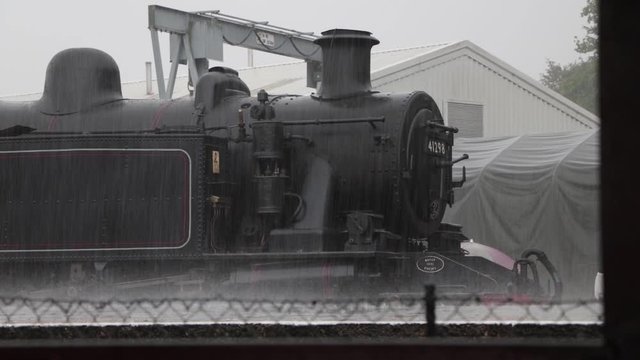 Extreme Weather, Heavy Rain On Train Station Platform With Steam Locomotive In Background