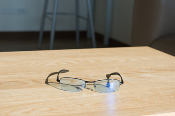 Eye glasses on table in room.soft focus.