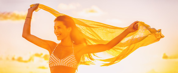 Happy Asian woman free in summer sunset glow feeling good carefree outside banner panorama. Yellow sunshine flare wellness person with scar.