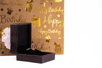 Cinnamon stone ring in lather gift box and carry bag on white background. Happy birthday concept