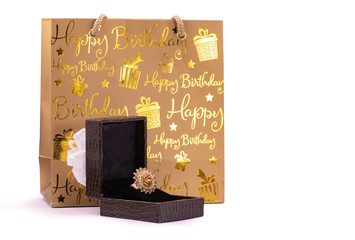 Golden ring in lather gift box and carry bag on white background. Birthday gift concept