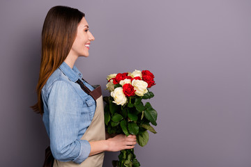 Profile photo of sale manager lady holding big bunch of roses delivering it to clients house wear jeans shirt covered by apron isolated grey background