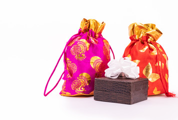 Potli bag or Dawstring bags and lather gift box decorated with white ribbon on white background
