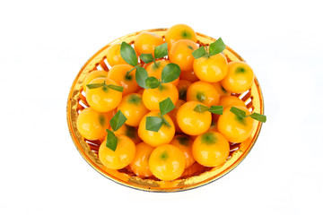 kanom Look Choup : Thai traditional dessert made from green been, coconut milk, sugar and jelly in orange shape put in gold tray : imitation deletable fruits