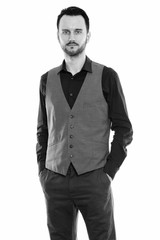 Studio shot of young man standing and wearing vest