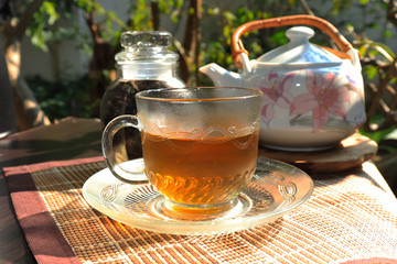 Green tea cups and glass jars with dry green tea