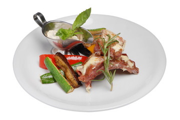 Steak with vegetables and white sauce on white plate on white isolated background