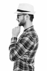 Profile view of young man thinking while wearing eyeglasses and hat