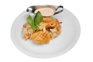Fried fish nuggets with white sauce on a plate on a white isolated background