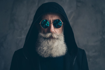 Close-up portrait of his he nice well-groomed attractive focused peaceful calm bearded gray-haired man wearing round blue violet specs life dream isolated on concrete industrial wall background - Powered by Adobe