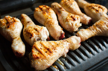 Marinated chicken legs fried on the hot flaming BBQ grill.