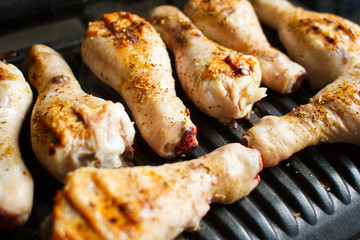 Marinated chicken legs fried on the hot flaming BBQ grill.