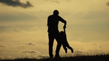 happy family funny concept teamwork father and son slow motion video. dad man and son boy silhouette swirls spinning lifestyle hands silhouette at sunset. happy sweet childhood