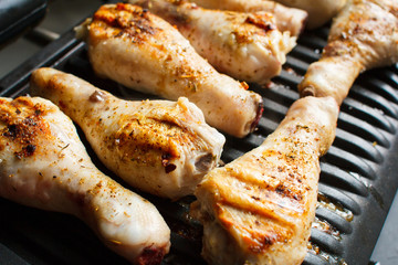 Marinated chicken legs fried on the hot flaming BBQ grill.