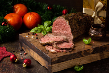 Juicy roast beef with spices sliced on cutting Board, delicious meat, traditional food. Christmas...