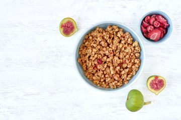 Granola for healthy breakfast. Bowl with granola and fresh fig and dried berries, top view	