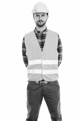 Studio shot of young man construction worker standing
