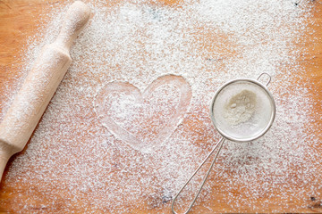 Dough with flour and rolling pin on the board. Ready, roll out the dough. Work baker. We bake rolls and pies in the kitchen
