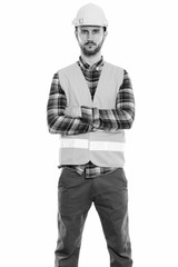 Studio shot of young man construction worker standing with arms crossed