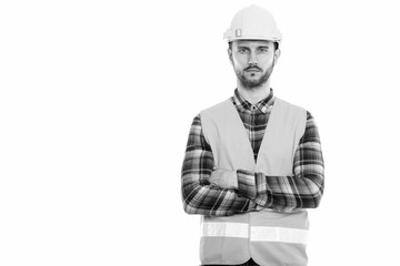 Studio shot of young man construction worker with arms crossed
