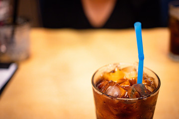 A glass of soft drink with ice on table