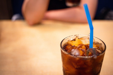 A glass of soft drink with ice on table