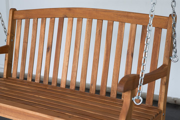 The detail of brown wood swing in the backyard.