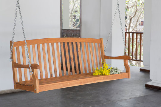 The brown wood swing in the backyard. - Powered by Adobe