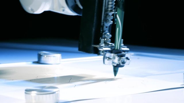 The machine draws an exact sketch of the details on paper. Robotic arm with pen drawing portrait at technology robotic exhibition. Device design. Automatic appliances