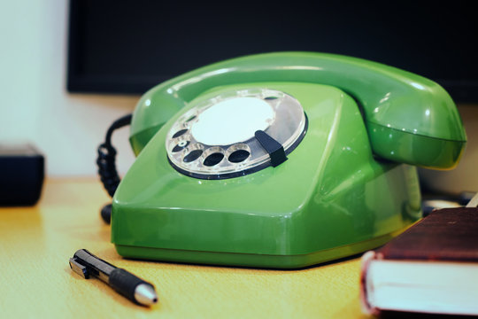 Old Green Rotary Phone On The Desktop.